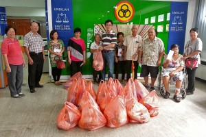 砂人联党青年总团长陈开移交白米和干粮食品以及新年红包予市内的贫穷家庭和不幸人士。