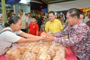 拿督杨昆贤赠送年柑给予摊主。