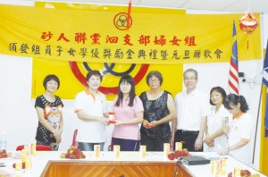 妇女组主席甲必丹胡淑娥（左二）颁发学优奖励金予一名学生，右三为青年团团长邓文武县议员。