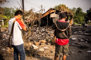 灾黎无助望着被烧成灰烬的家园。