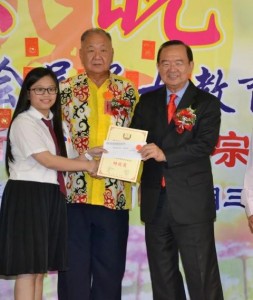 A pupil getting an excellent award from Peter Chin