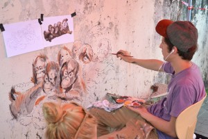 尔纳斯在墙上专注作画。