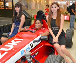一名“幸运儿”坐上赛车与美女合影。