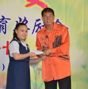 Dato' Sebastian Ting giving an incentive to a pupil
