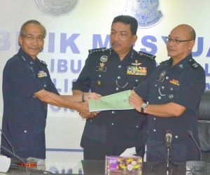 在砂州警察总监拿督威拉莫哈末沙都见证下，莫舍斯助理总监（左）移交肃毒组主任职权书予鲁卡斯。