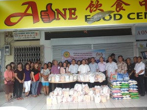 受惠的贫困家庭代表在领取日用品后与主宾拿督叶金来与社区领袖及巿议员等合影。