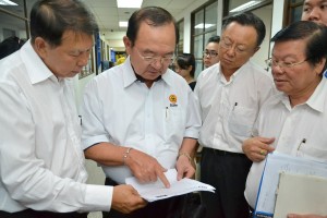 党主席陈华贵与众领袖查阅文告，左为宣教秘书陈超耀，右起为组织秘书叶金来、埔奕支部主席谢超发。