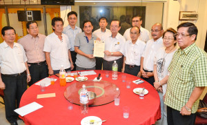 在众党领袖陪同下，党主席陈华贵移交委任文件予文莪支部代主席黄任瑞。