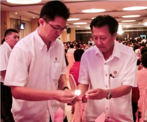 Robert Lau left and Chieng Buong Toon lighting a candle for those who had passed on as a remembrance