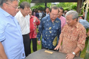 众人对詹玛欣住家花园的巨石感兴趣，左起为张庆信、陈超耀及陈华贵。
