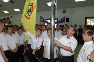 Peter Chin raising the flag joined by former party leaders and members