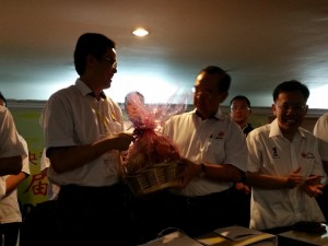 Tan Kai presenting a souvenir to Peter Chin 