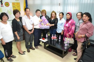 Serian welfare association chairperson Wisdon Hoan (left fifth) giving a souvenir to Datuk Sim.