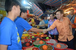沈桂贤向摊主们献上问候。