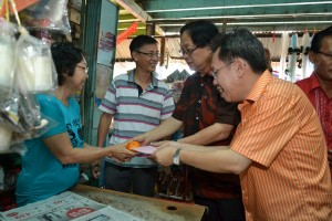 沈桂贤及法兰西哈登齐齐向商家送上年柑和贺年卡。