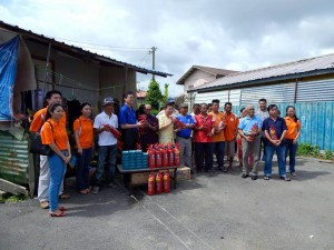 砂人联党主席拿督沈桂贤与青年团团长陈开移交灭火器予地方居民。