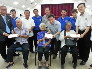 砂人联党党主席拿督沈桂贤上议员与古晋省省长苏卡敏及人联党巴都林当支部主席薛华东派发一马援助金兑换券给予现场3名乐龄人士。