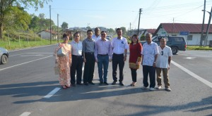 巴达旺市议会主席罗克强与众人在经过扩建后的7哩双溪达邦路路口合影，左起为人联党中央妇女组顾问郑莉薲、社区领袖本固鲁贝文美、公共工程局古晋省工程师阿旺莫哈末法迪拉、公共工程局技术人员拉美斯、罗克强、市议员叶耀星、人联党哥打圣淘沙支部妇女组主席钟昉霏、社区领袖甲必丹田德兴及居民贝德聪。 