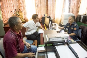 Photo shows SPCB Chief Wilfred Yap assisting the resident of BDC Resettlement Scheme with the renewal of his TOL at Land & Survey Department, Kuching Divisional office