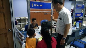 Photo shows SUPP PCB Chief Wilfred Yap together with the single mother and her son at the National Registration Department, Kuching