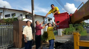 图为为石角支部秘书林亚德（左一）、石角永明村居民郑氏（左二）与国会上议员沈桂贤医生（右二）将路灯零件移交予安装人员。