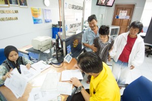 Photo shows SUPP PCB Chief Wilfred Yap together with the father and his intellectually challenged son at the National Registration Department, Kuching