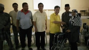 Dr. Sim handing over the wheelchair to one of the recipients.