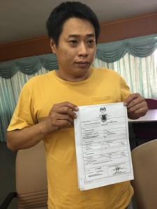 Terry Tay shows the unnumbered birth cert of his son Jordan