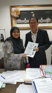 Ting handing the report to Khatun Ali