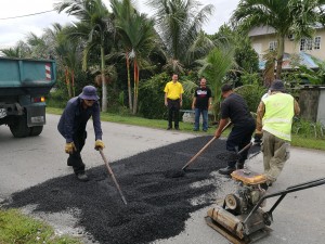 SUPP PCB Chief Wilfred Yap with MPP road maintenance staff during the resurfacing and maintenance works at Kampung Semaba.