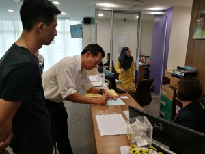 SUPP PCB Chief Wilfred Yap assisting the anxious father from Foochow Road, Kuching at the Kuching District Office to submit his application for a Certificate of Adoption