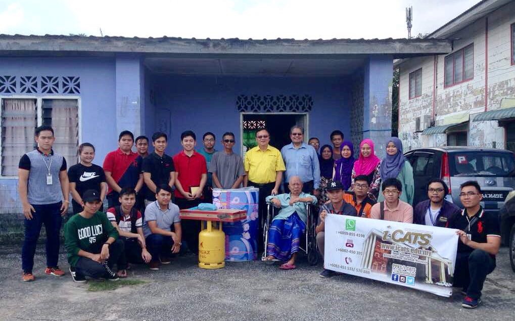 YB. Cr. Ir. Lo Khere Chiang (in yellow shirt) presenting a new gas stove, gas cylinder and mattress to En Tekong bin Darmo (sitting in wheelchair)