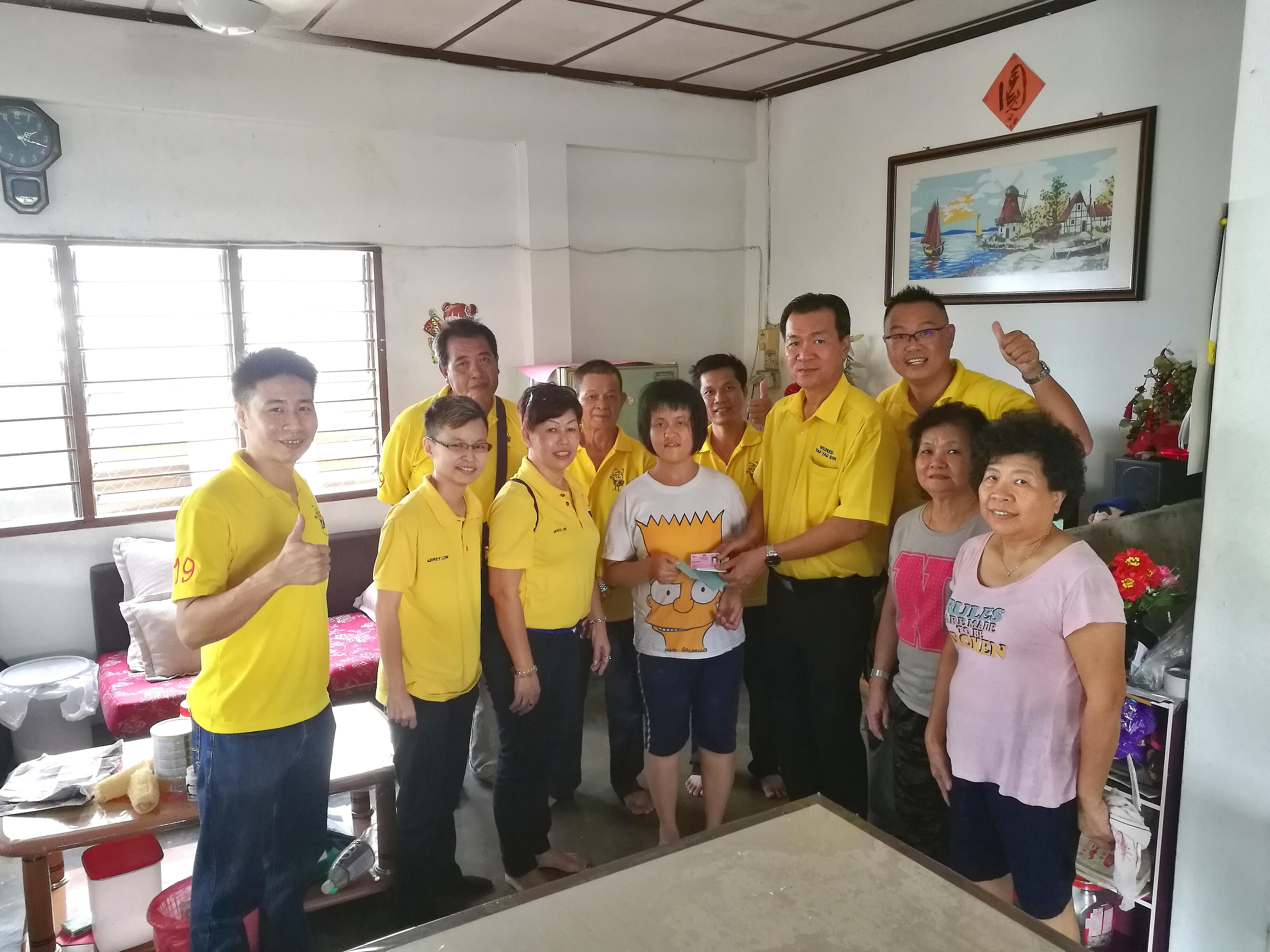 SUPP PCB Chief Wilfred Yap and SUPP members visiting the individual to inform her that her welfare incentive allowance had been approved by the Social Welfare Department