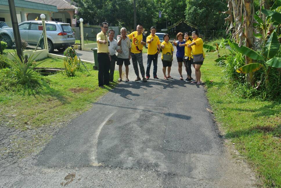 SUPP PCB Chief Wilfred Yap with SUPP members and residents of Lorong 41, Stampin Resettlement Scheme inspecting the repaired road and SUPP PCB Chief Wilfred Yap inspecting the newly painted road at the entrance of Lorong 2, Stampin Resettlement Scheme