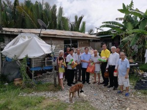 SUPP PCB Chief Wilfred Yap together with Temenggong Tan Joo Poi, Penghulu Thian Sing Hua, Kapitan Chai Yong Liang and other community leaders handing over some food items to the family at Lorong 28, Stampin Resettlement Scheme