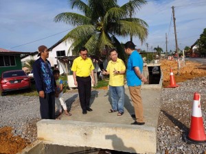 Dr. Sim and Lo seeing the progress of the drain