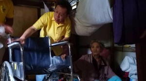 沈桂贤移交轮椅给行动不便者。