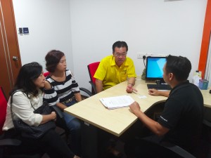 Yap with Kapitan Kho and the women fast food seller in discussion with an officer of  Companies Commission of Malaysia.