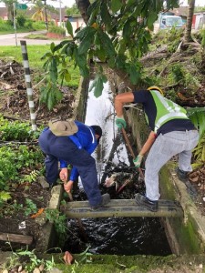 Public Works Department (JKR) workers clearing the drainage system at the inundated road.